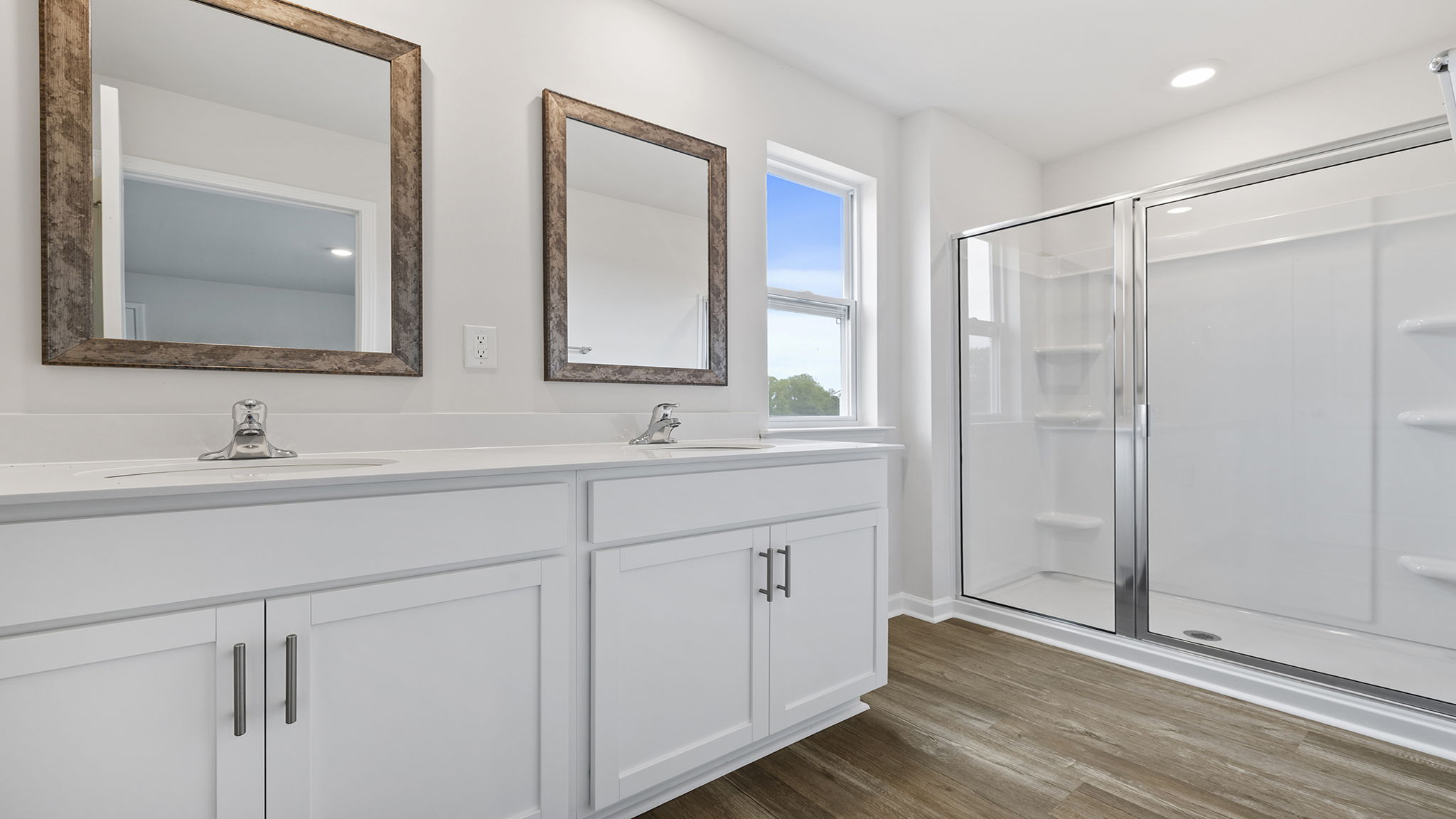 Primary bathroom with dual sink vanity and walk-in shower.