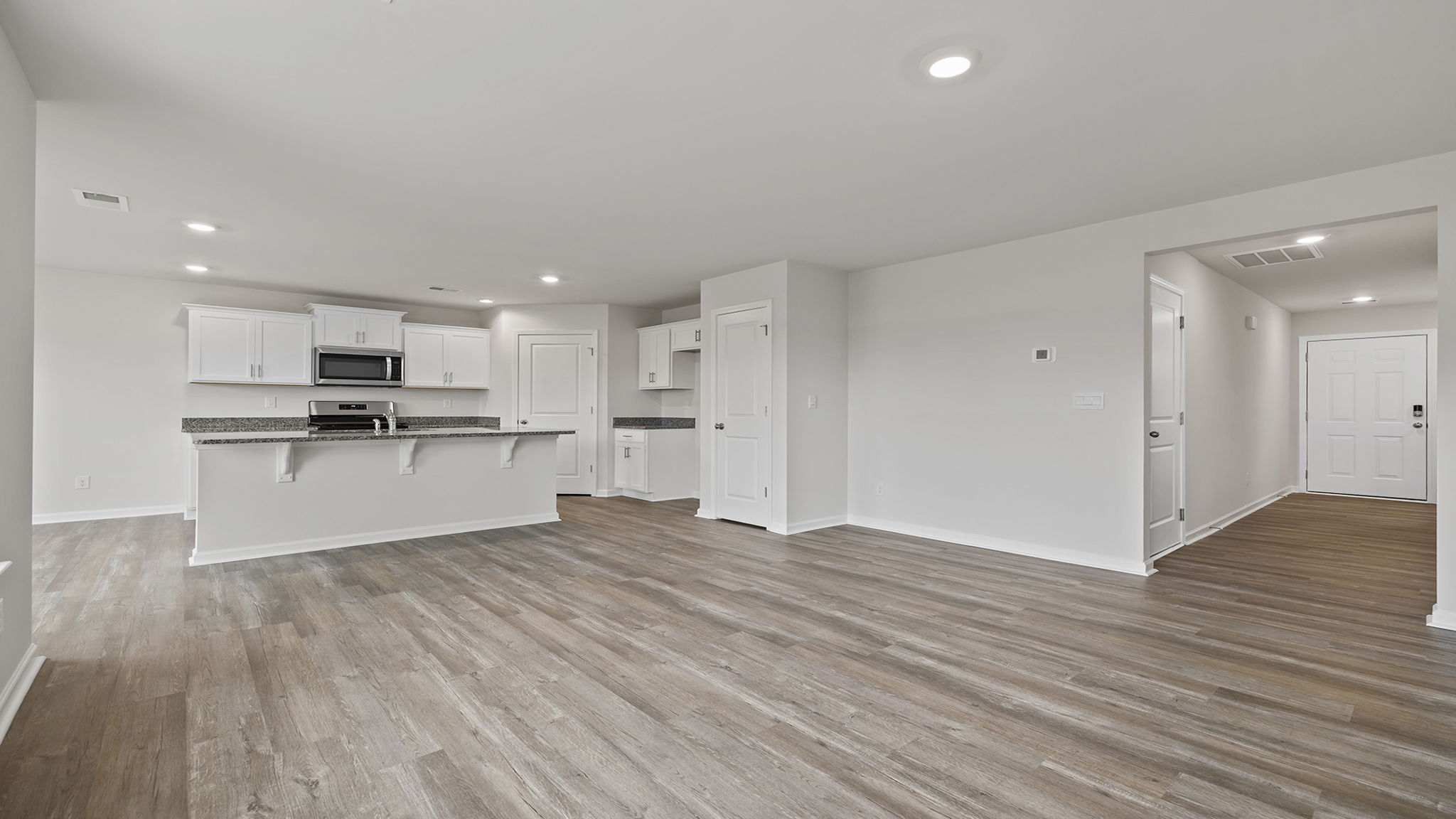 View of kitchen and hallway to the entrance from family room.
