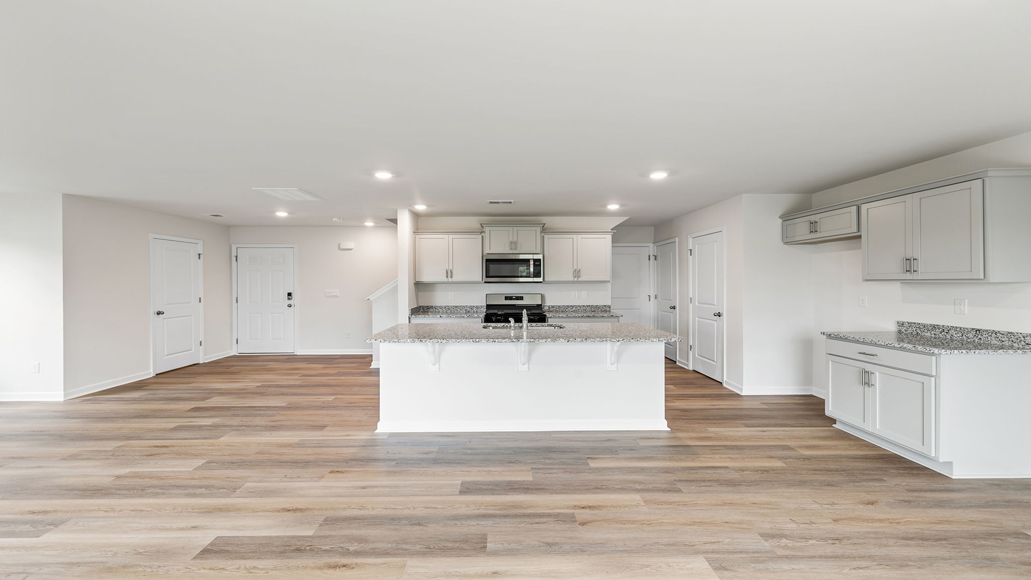 View of kitchen with island and recessed lights.