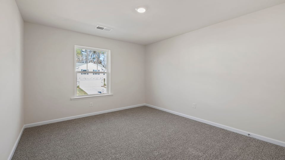 Bedroom with carpet and window.