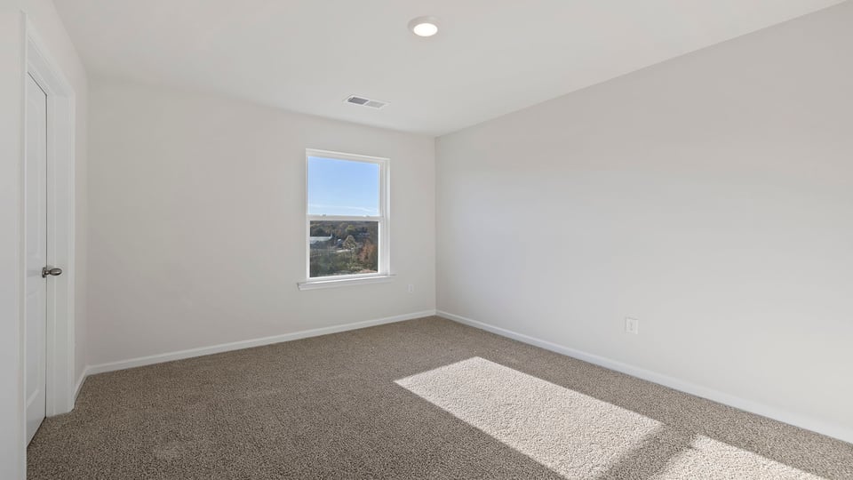 Bedroom with carpet and window.
