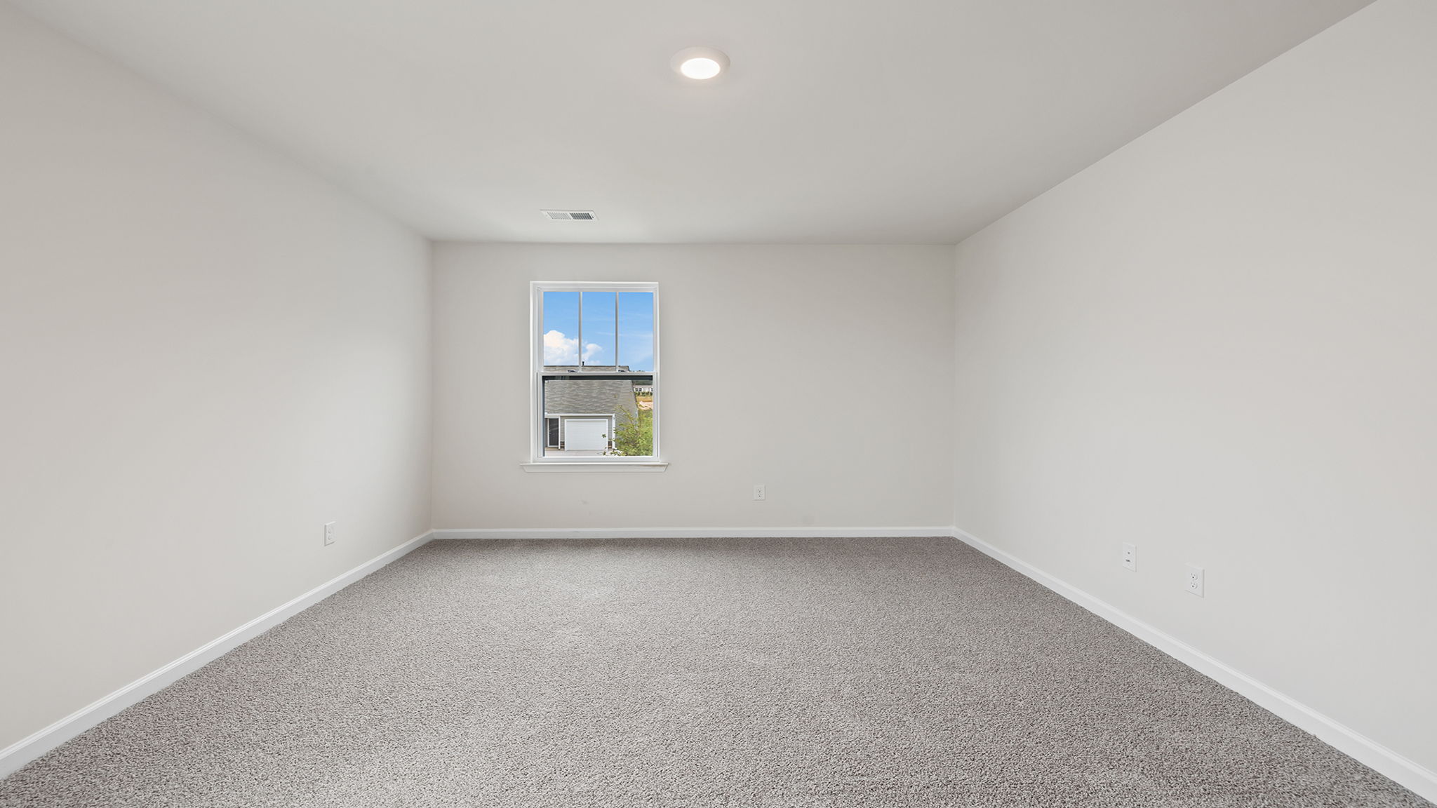 Primary bedroom with window and carpet.