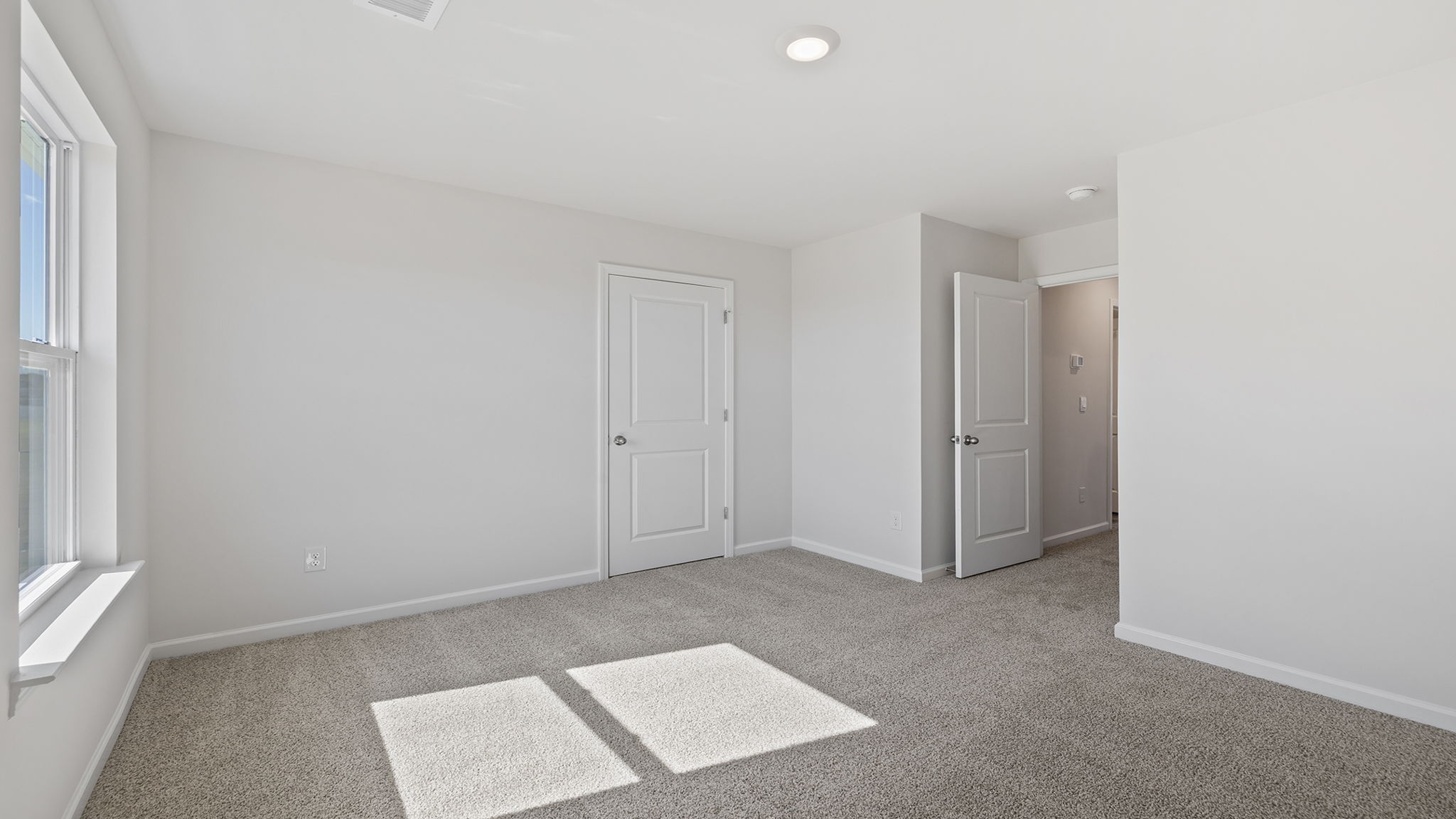 Bedroom with window and carpet.