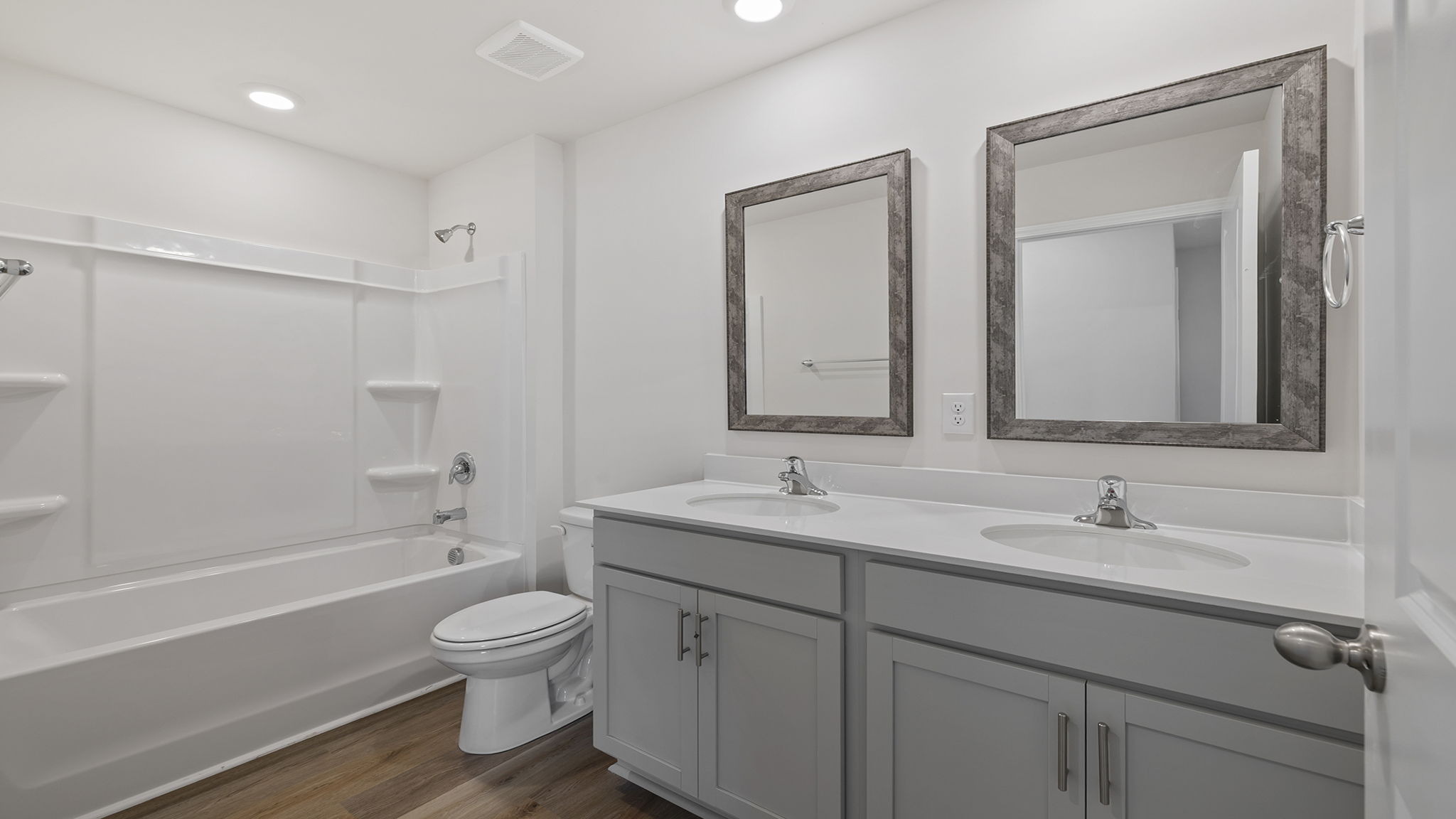 Hall bathroom with dual sink vanity with combination shower / tub.