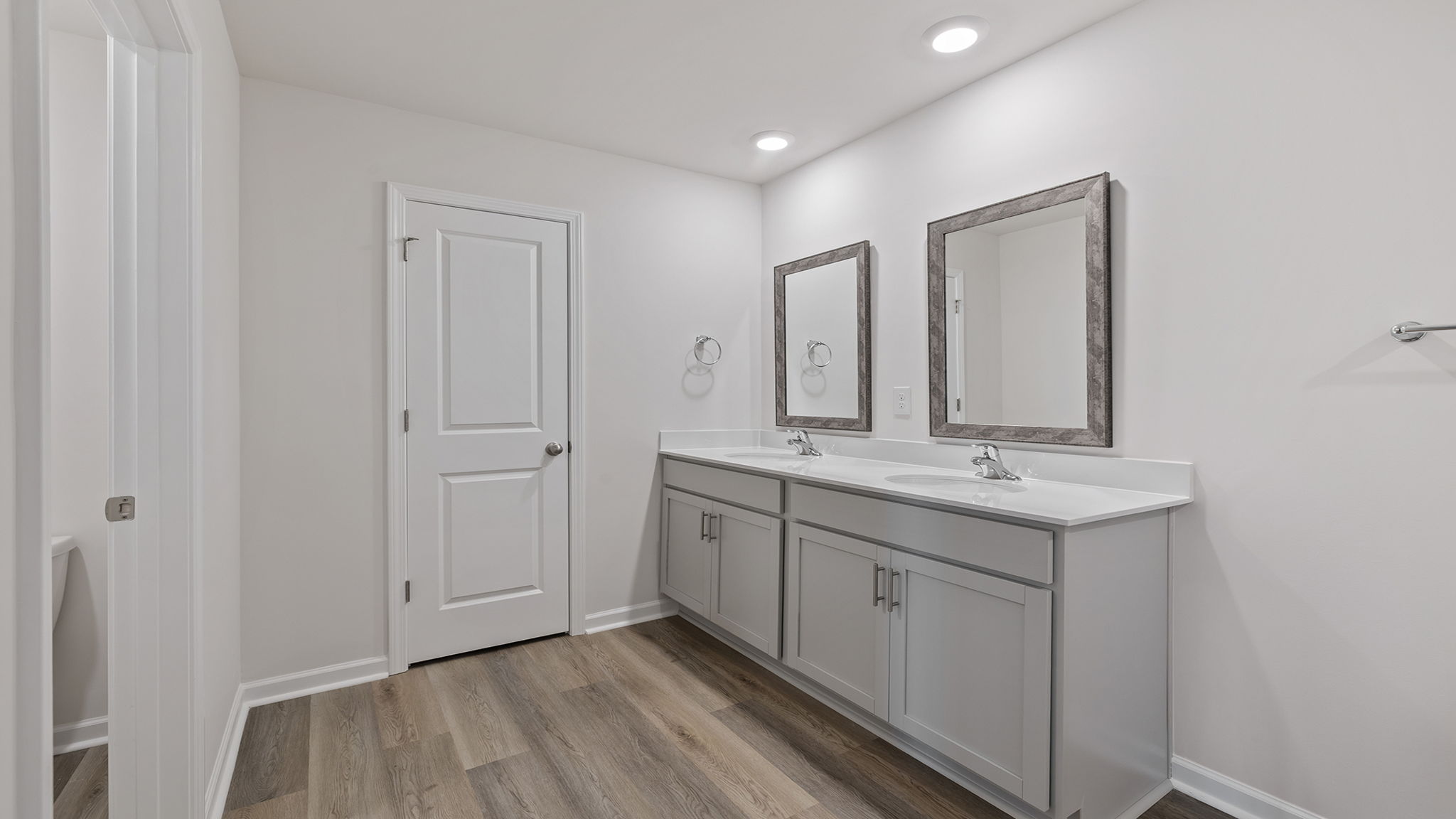 Primary bathroom with dual sink vanity and mirrors.