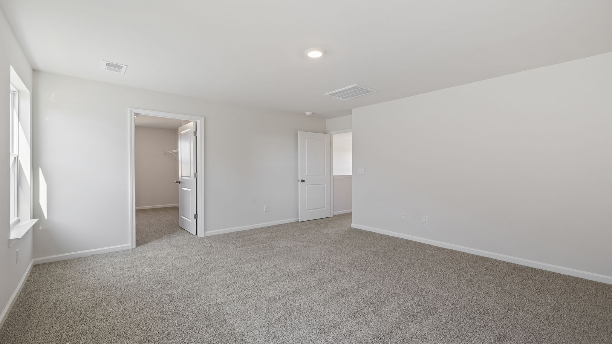 Primary bedroom with large windows.