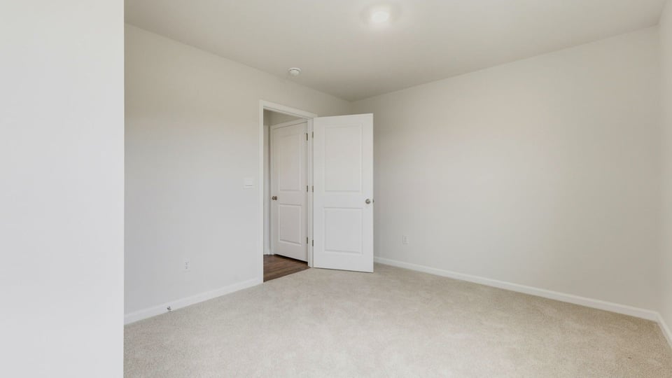 Bedroom with carpet and window.