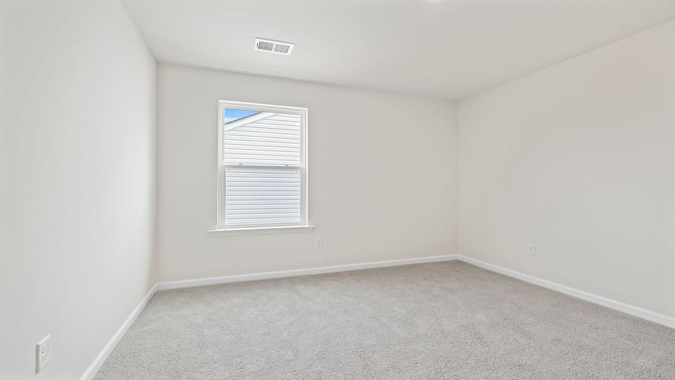 Bedroom with carpet and window.