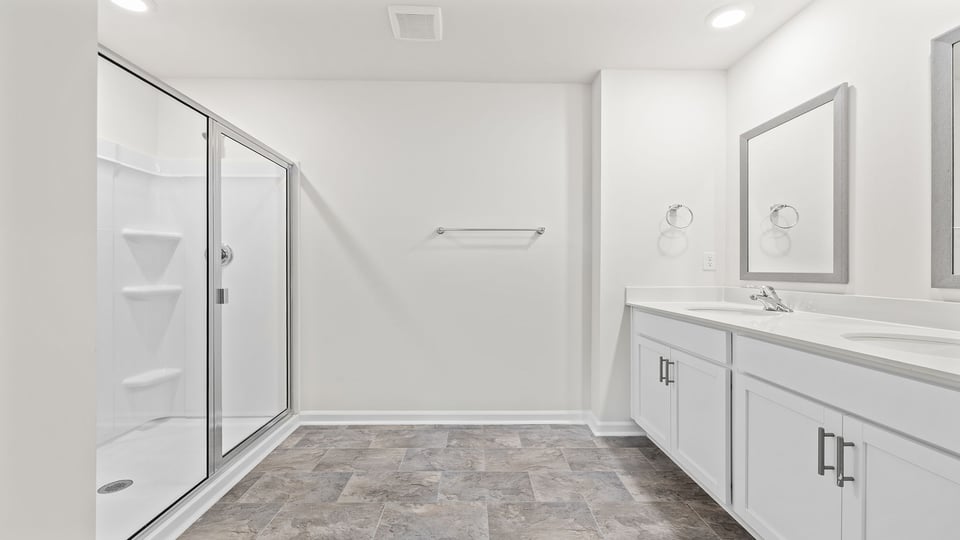 Bathroom with double vanity sink and walk in shower.