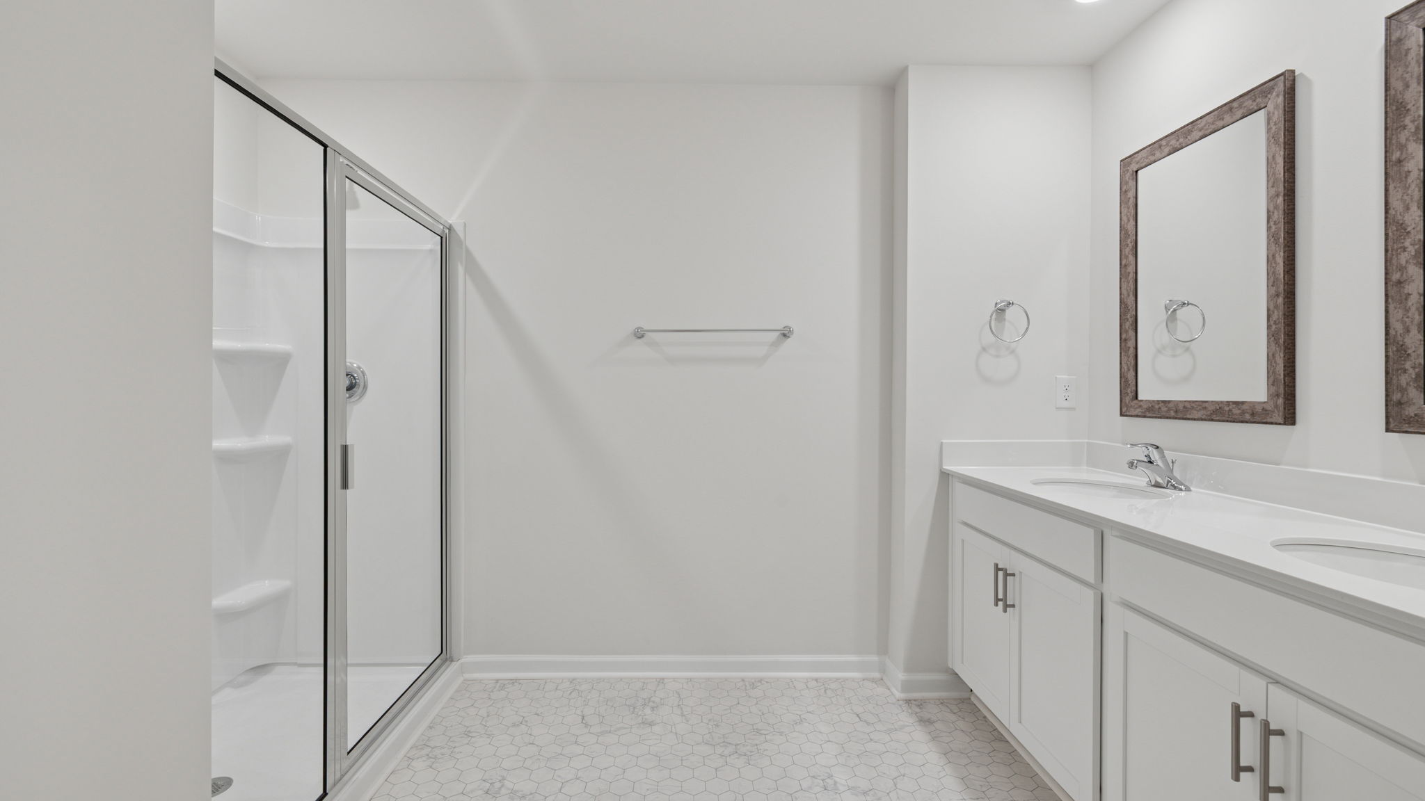 Primary bathroom with dual sink vanity and walk-in shower.