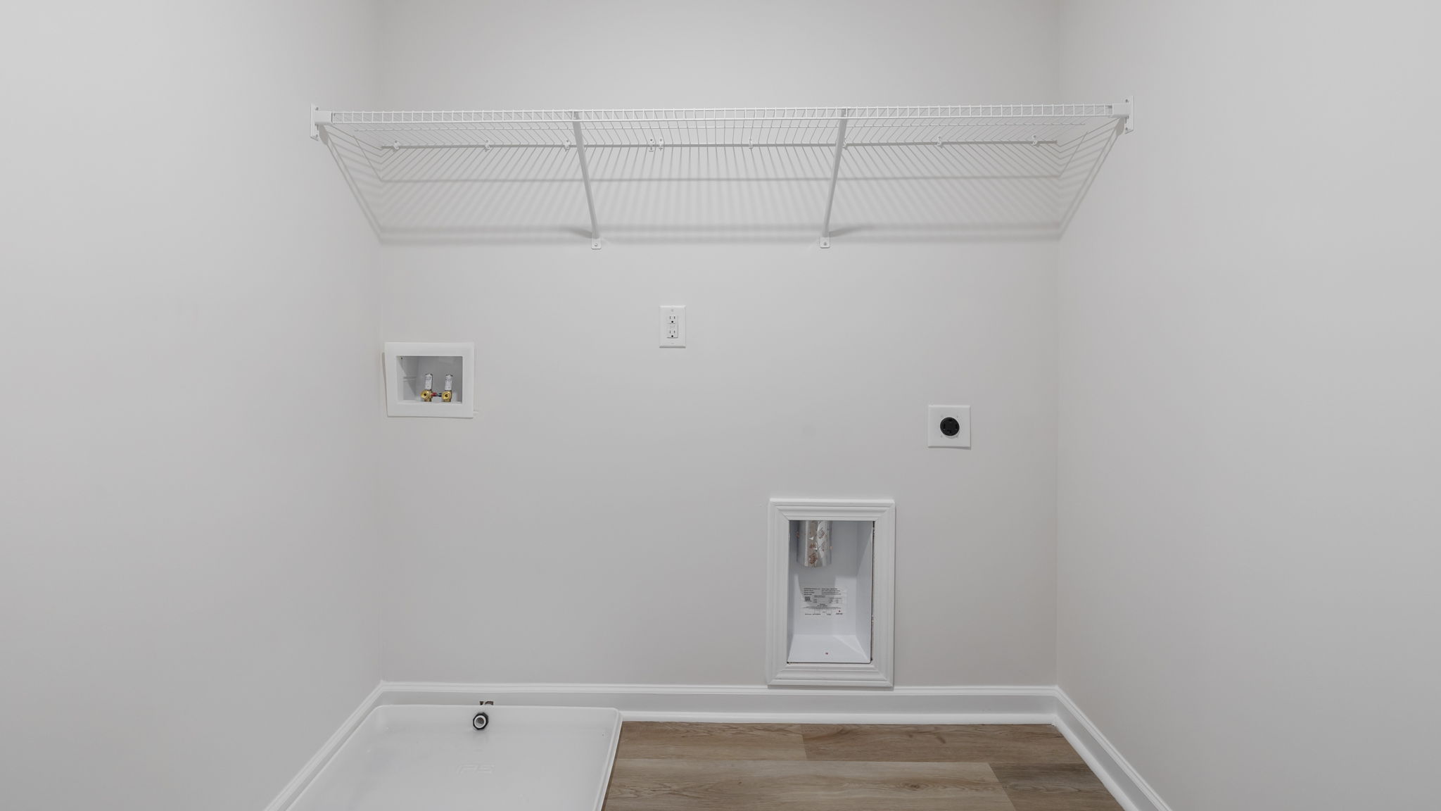 Walk-in laundry room with shelving.