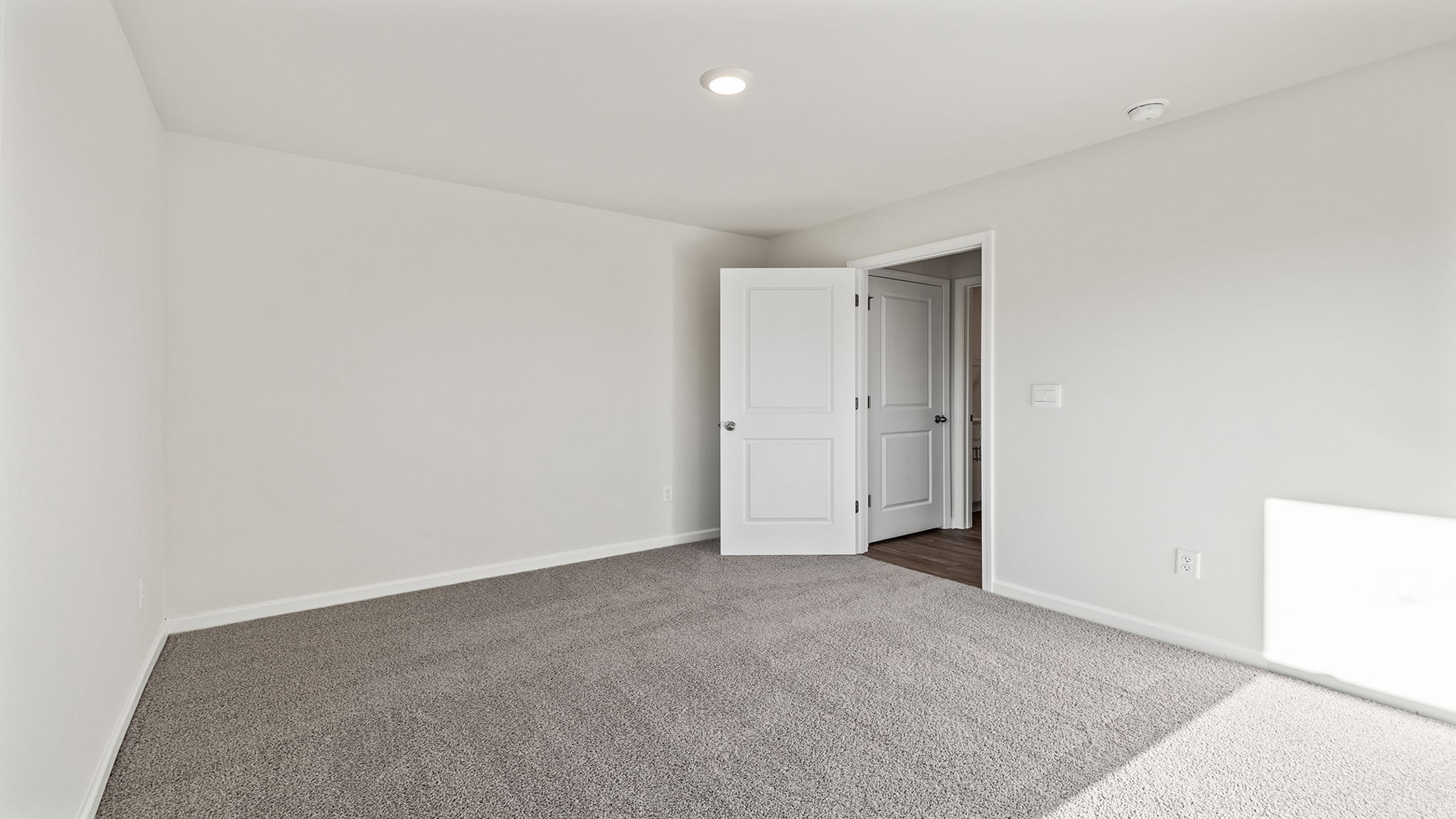 Bedroom on main level with carpet and window.
