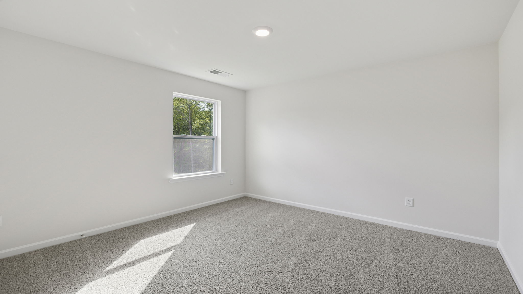 Bedroom with carpet and window.