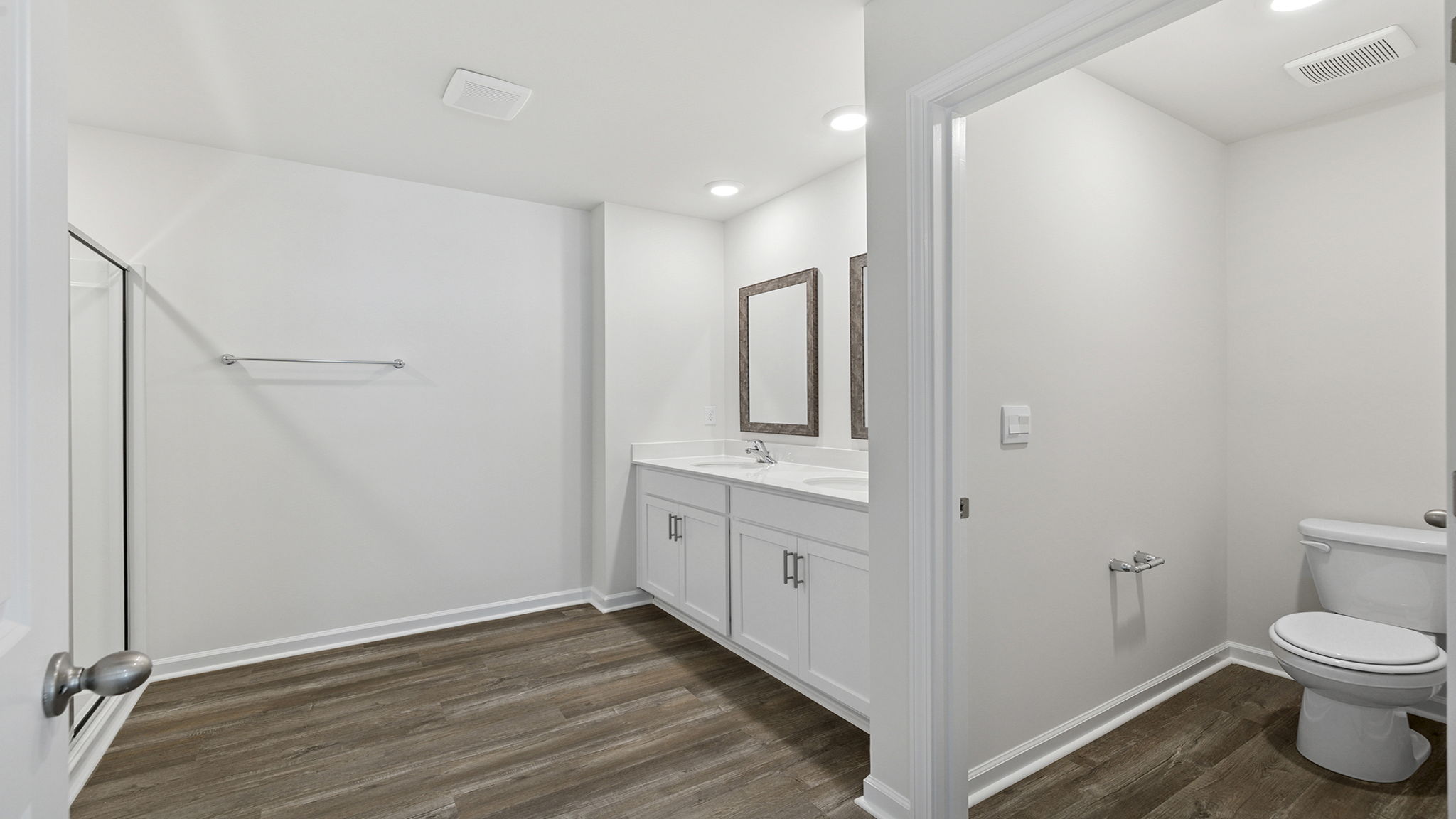 Primary bathroom with dual sink vanity and walk in shower.