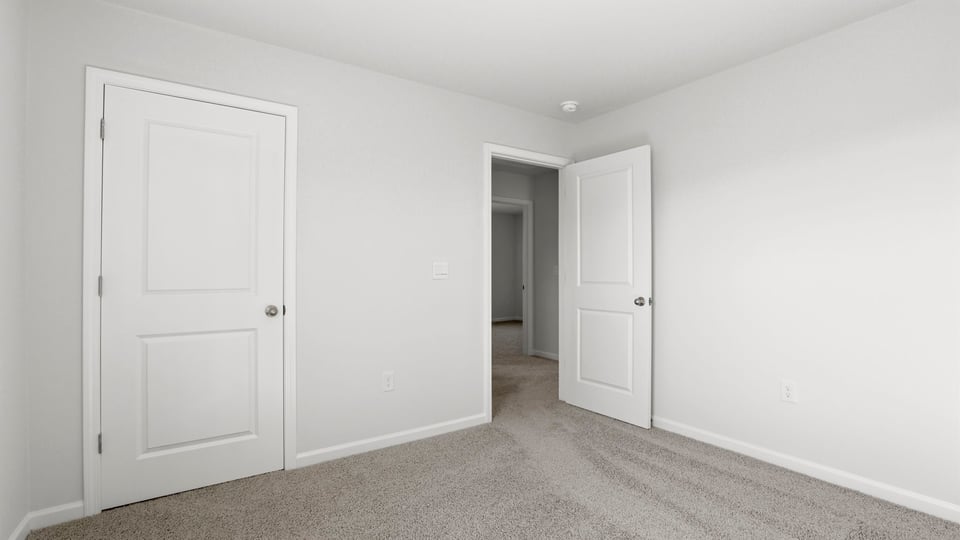 Bedroom with carpet and windows.