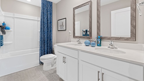 Bathroom with double vanity sink and tub.