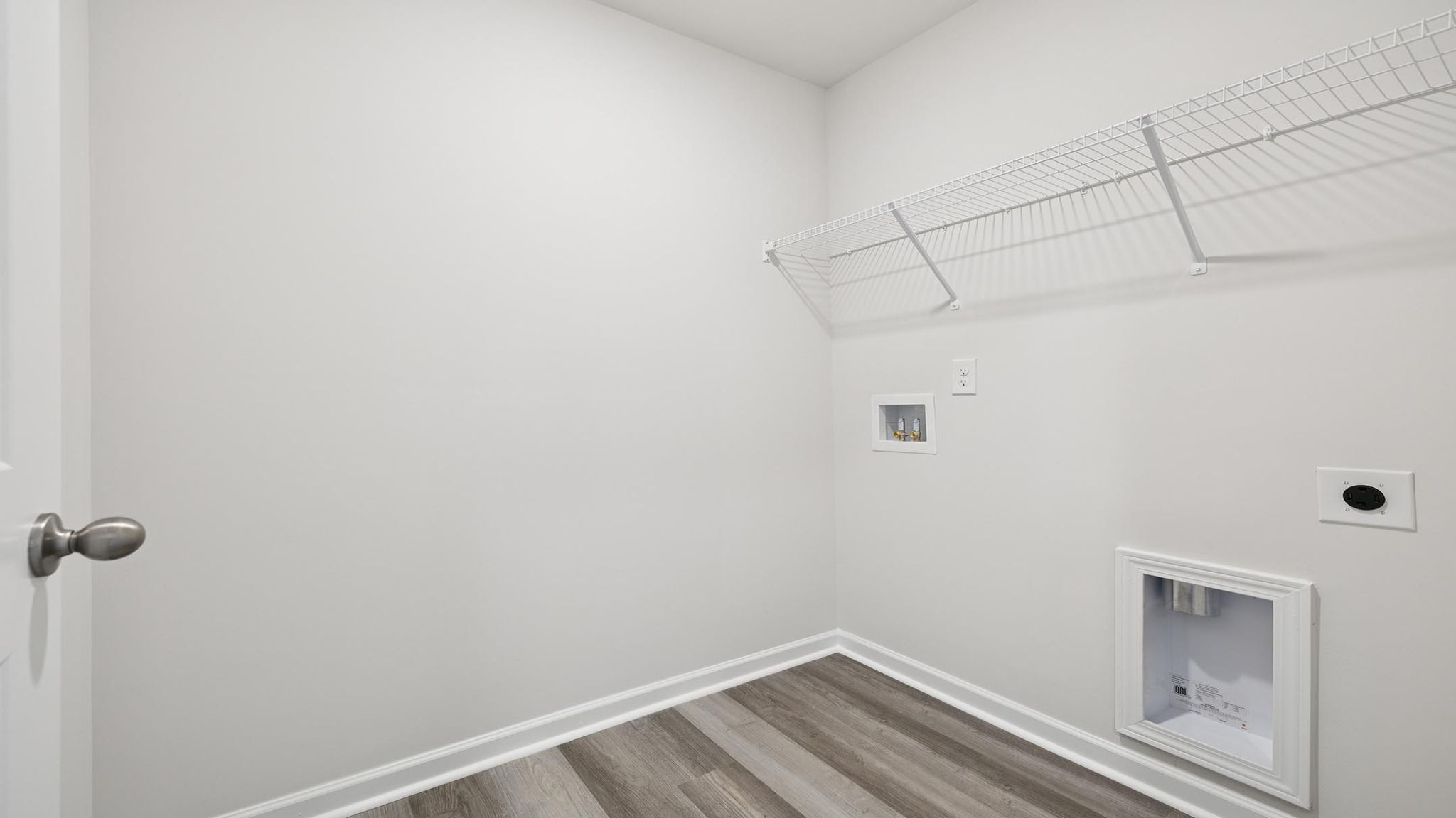 Walk-in laundry room with shelving.