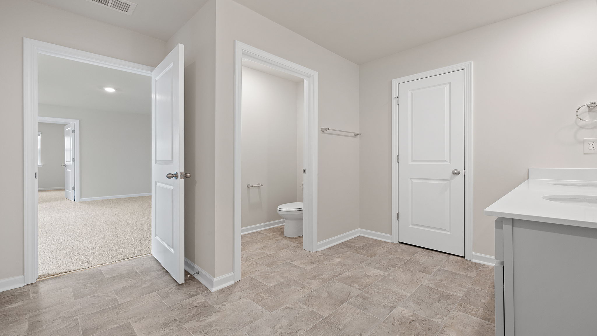 Primary bathroom with dual sink vanity and mirrors.