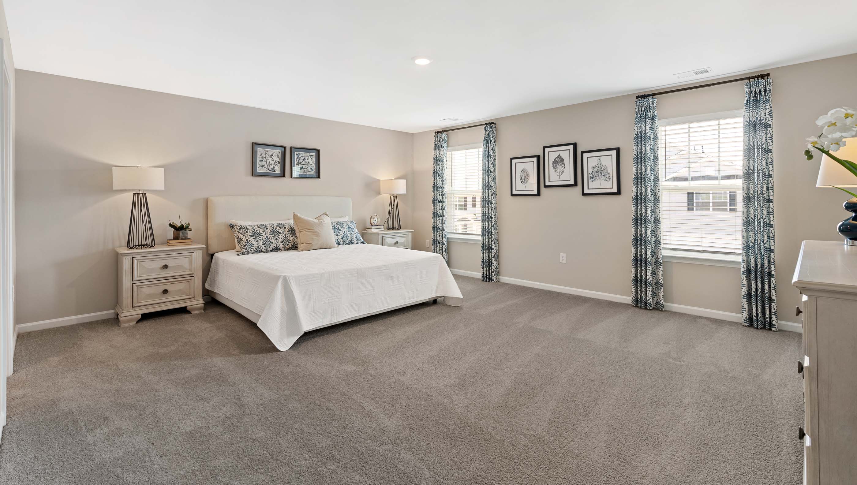 Primary bedroom with carpet and window.