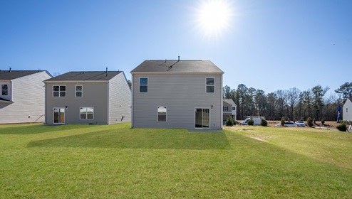 Back exterior of home with large backyard.