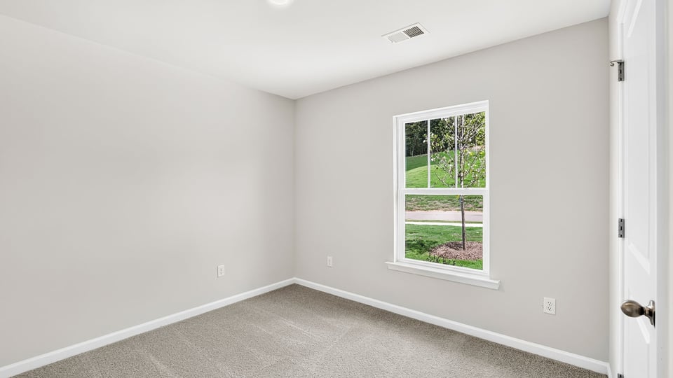 Bedroom with carpet and window.