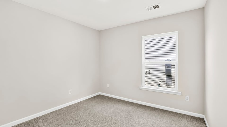 Bedroom with carpet and window.