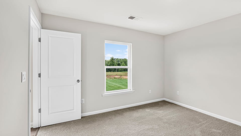 Bedroom with carpet and window.