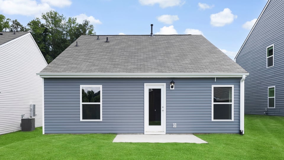 Back exterior of home with large backyard.