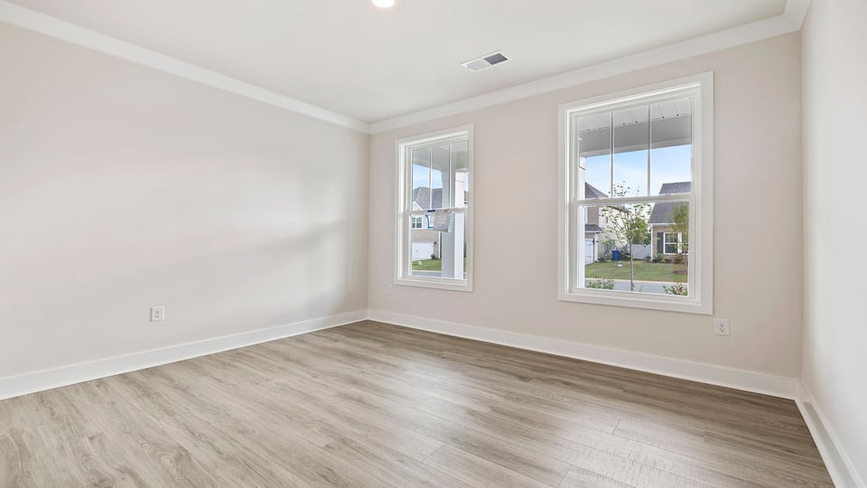 Bedroom with window and laminate flooring.