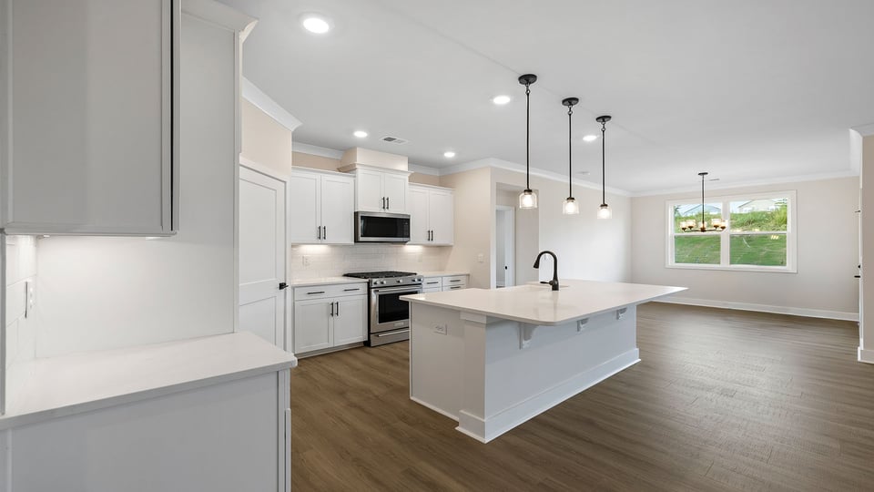View of the open kitchen and island with quartz countertops.