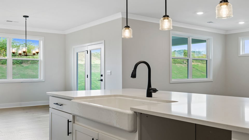 Kitchen island hosts the sink and dishwasher as it overlooks both the dining area and family room.