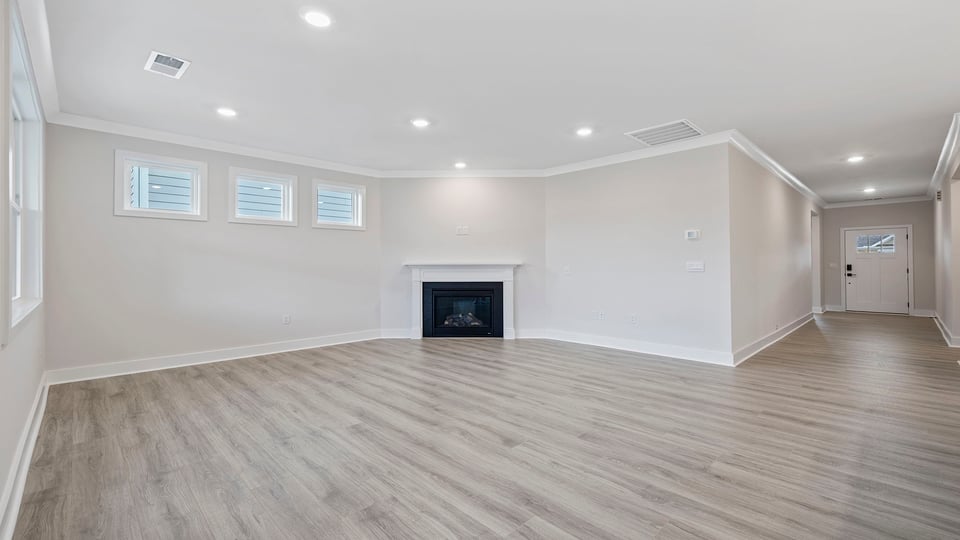 View of the family room with windows, recessed lighting and gas log fireplace.