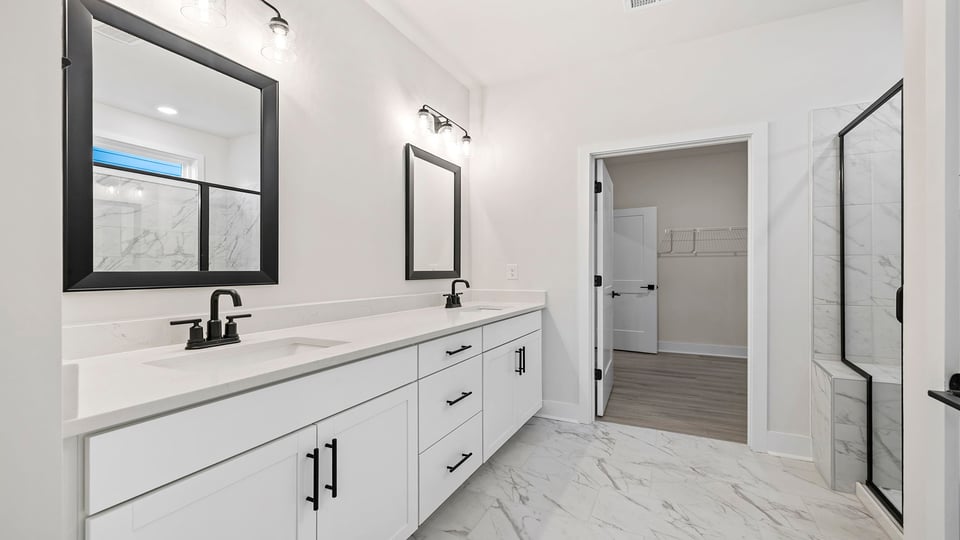 Primary bathroom with dual sink vanity and mirrors.