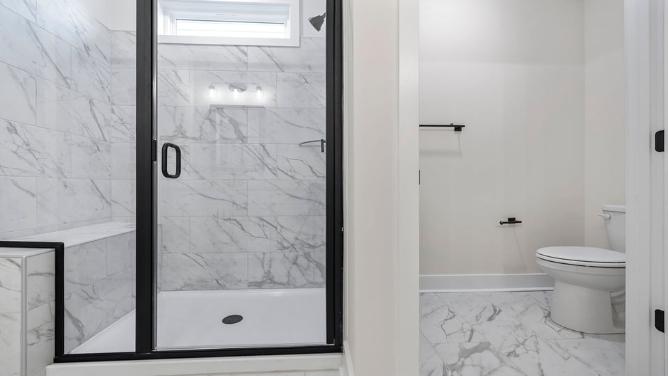 Primary bathroom with large walk-in showe4r and toilet area.