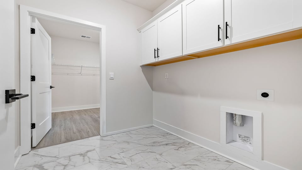 View of the walk-in laundry room with cabinets.