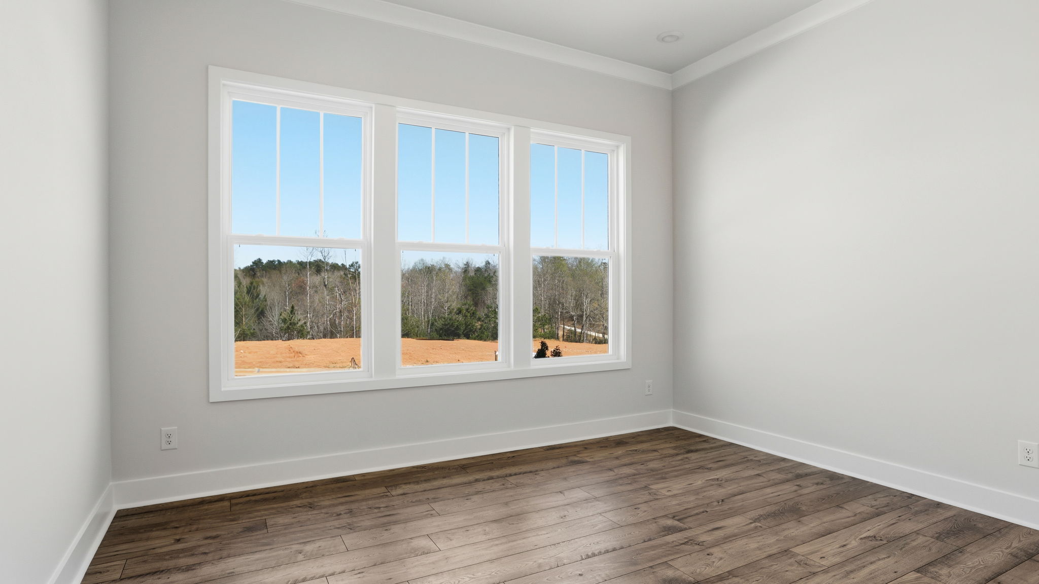 Bedroom with window and laminate flooring.