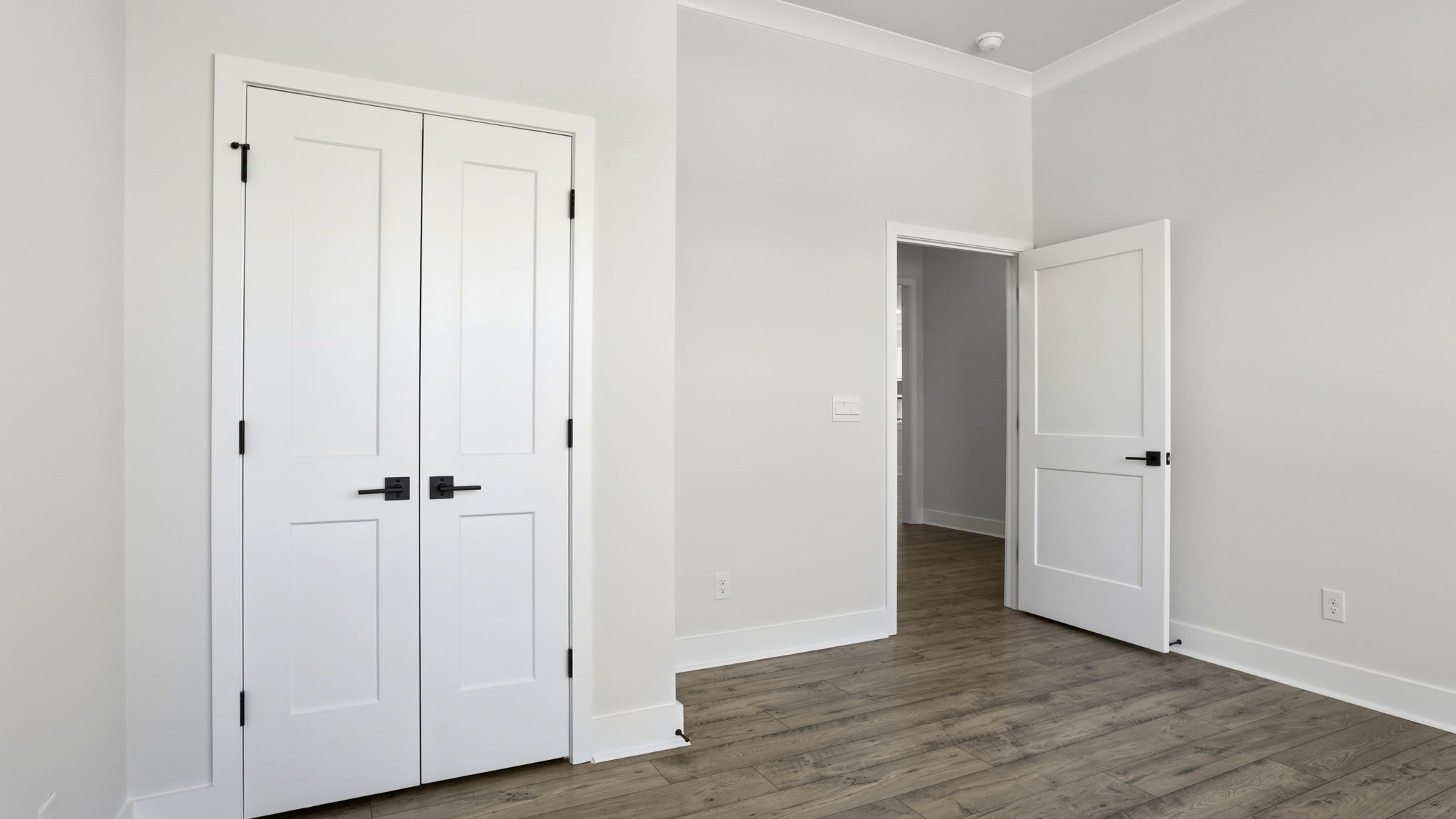 Bedroom with window and laminate flooring.