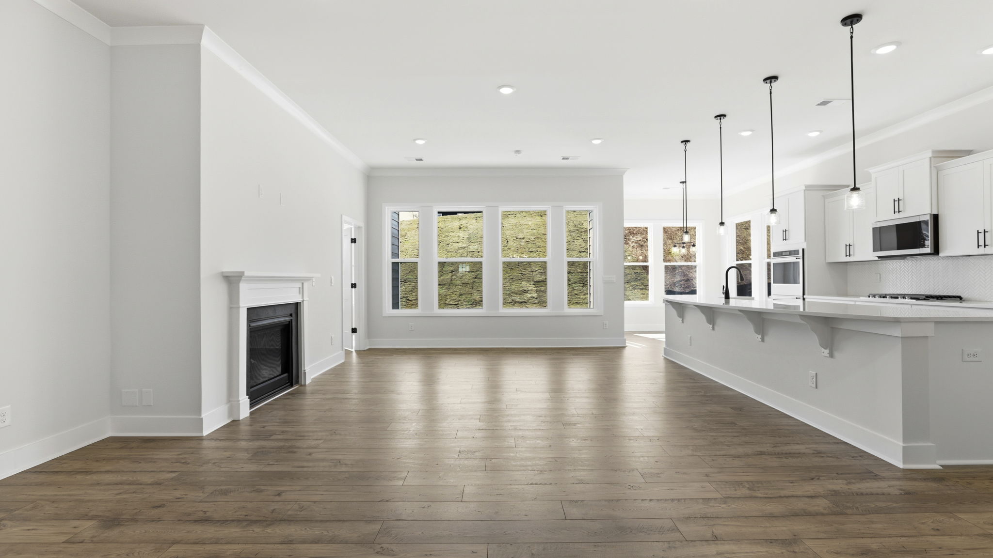 View of open floor plan with wall of windows that let in the natural sunlight.