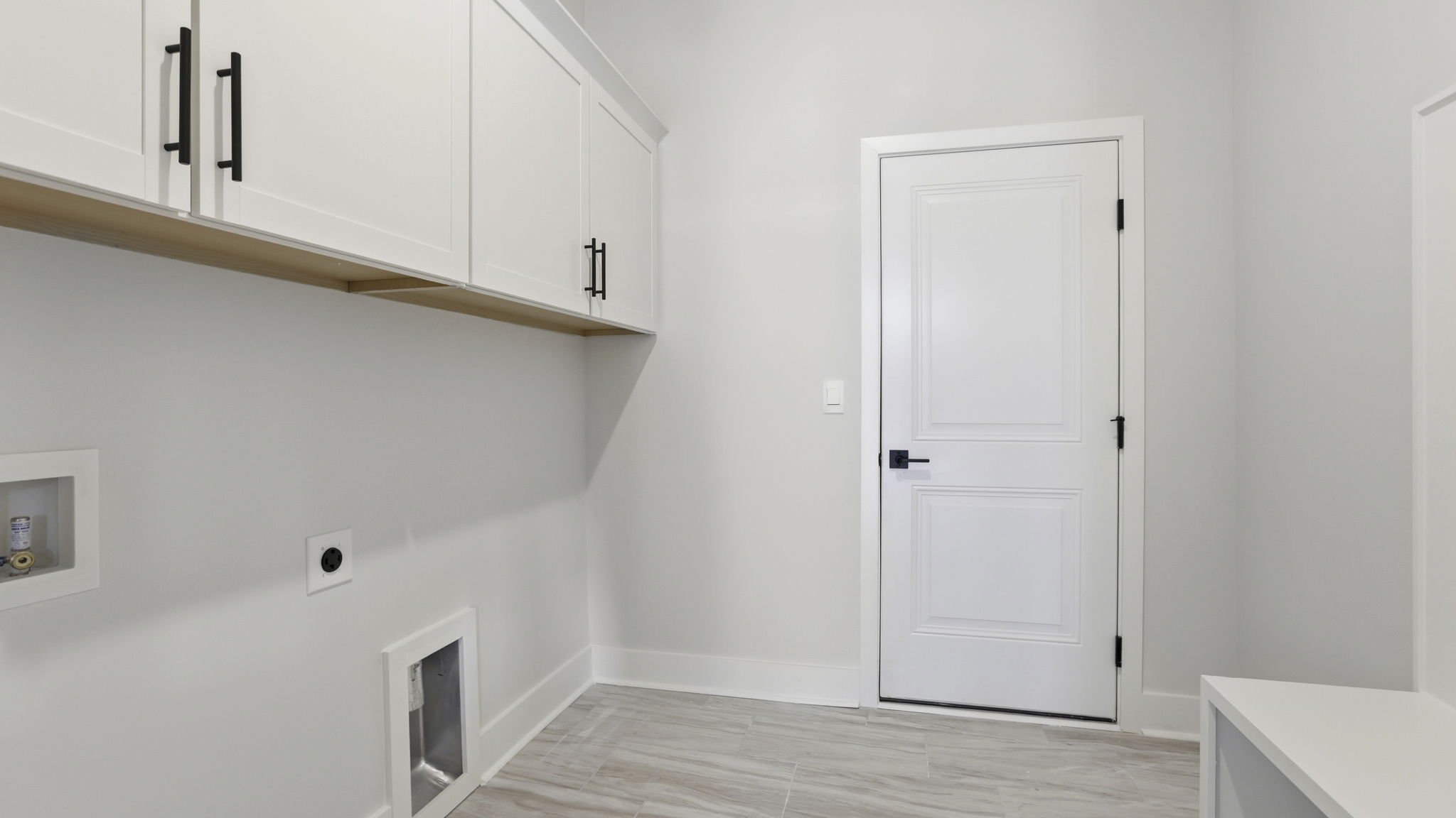 Laundry room with cabinets.