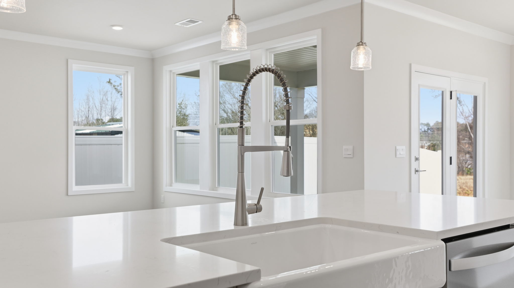 Kitchen island hosts the sink and dishwasher with a view of both the dining and family area.