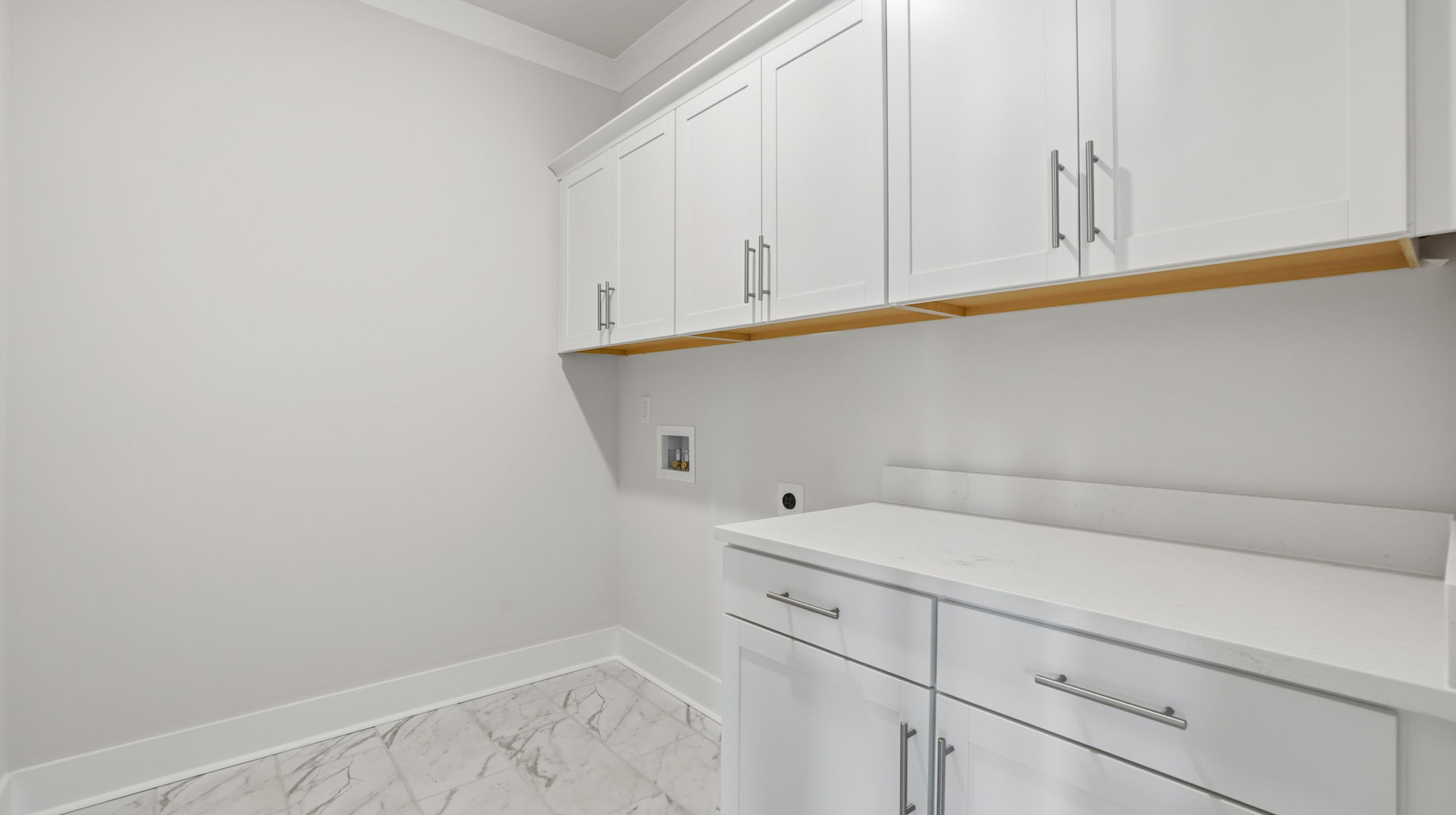 Walk-in laundry room with cabinets.
