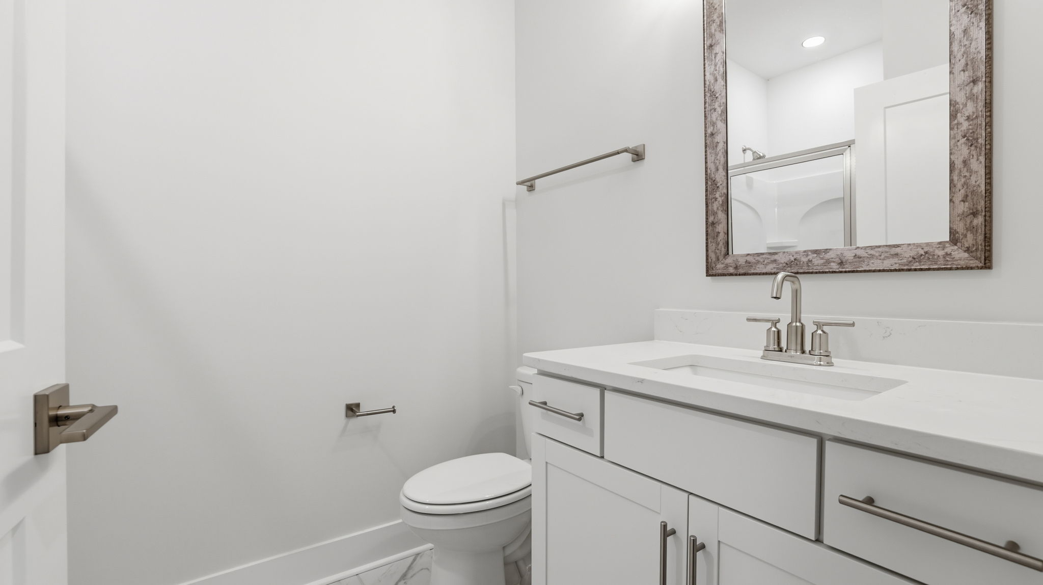 Hall bathroom with double sink vanity and combination shower / tub.