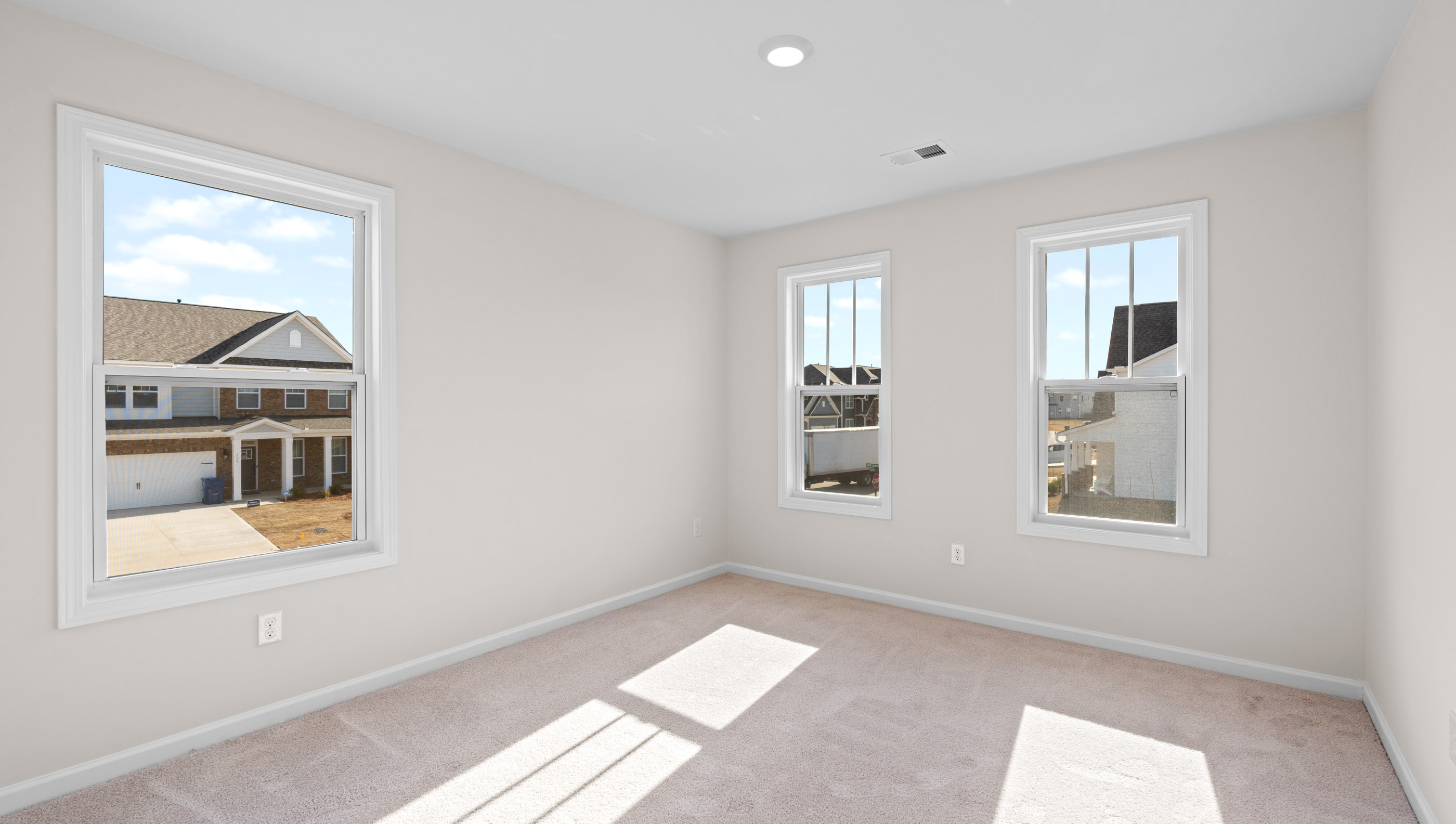 Bedroom with carpet and windows.