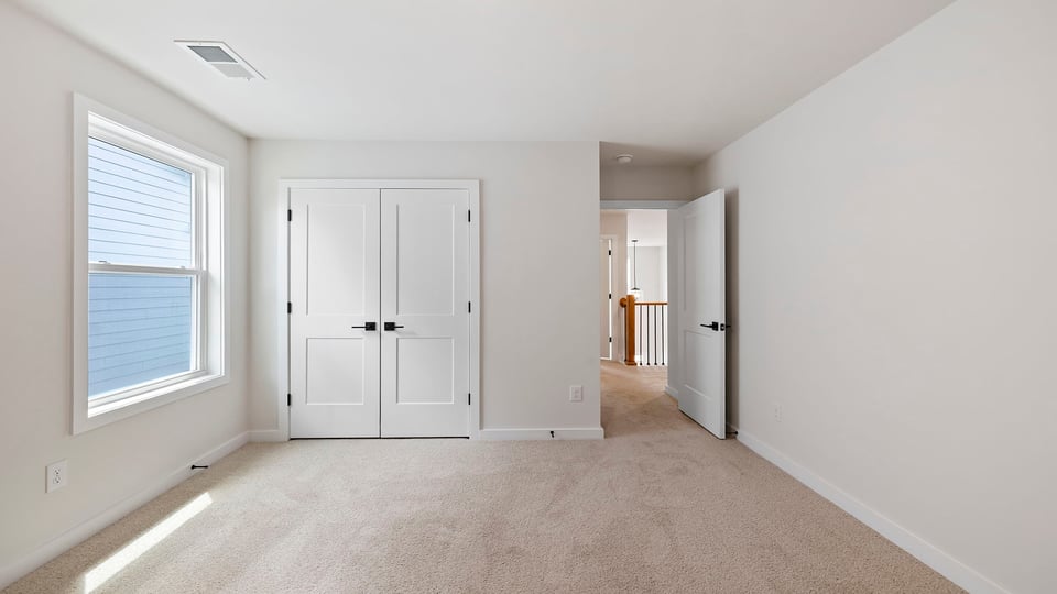 Bedroom with carpet and windows.