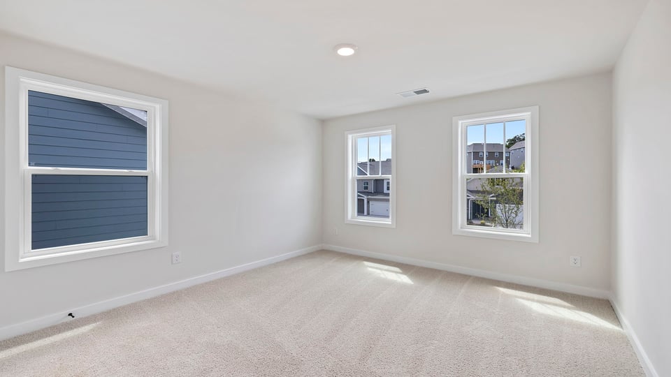 Bedroom with carpet and windows.