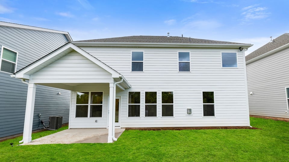 Back exterior with large backyard and patio.
