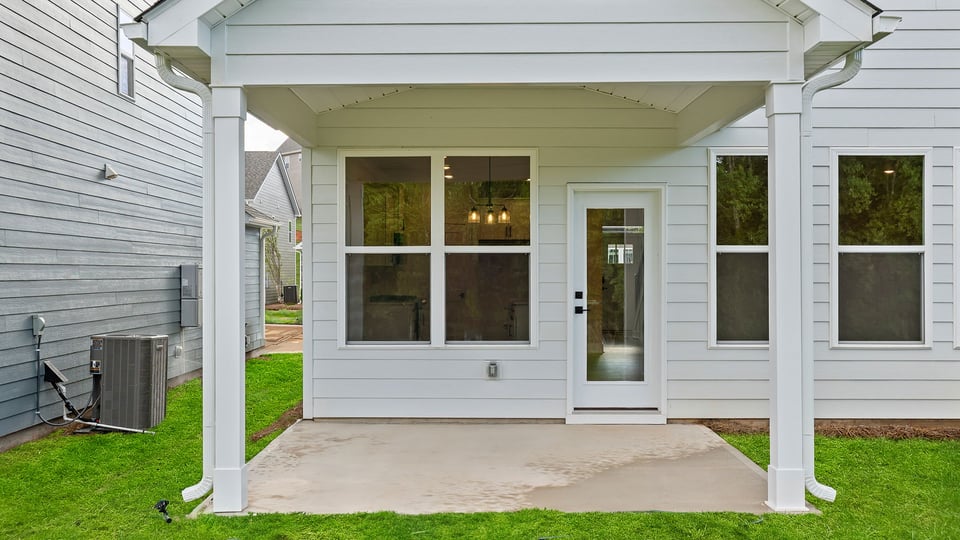 Back exterior with large backyard and patio.
