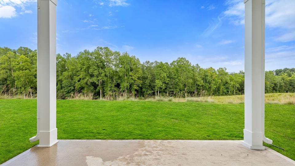 Back exterior with large backyard and patio.