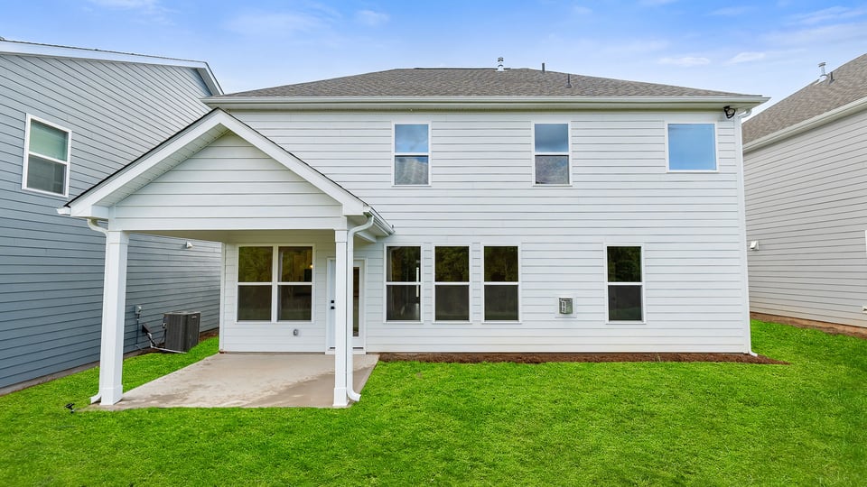 Back exterior with large backyard and patio.