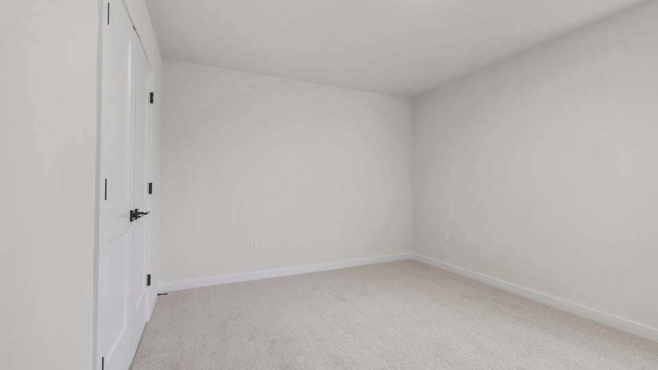 Bedroom with carpet and windows.